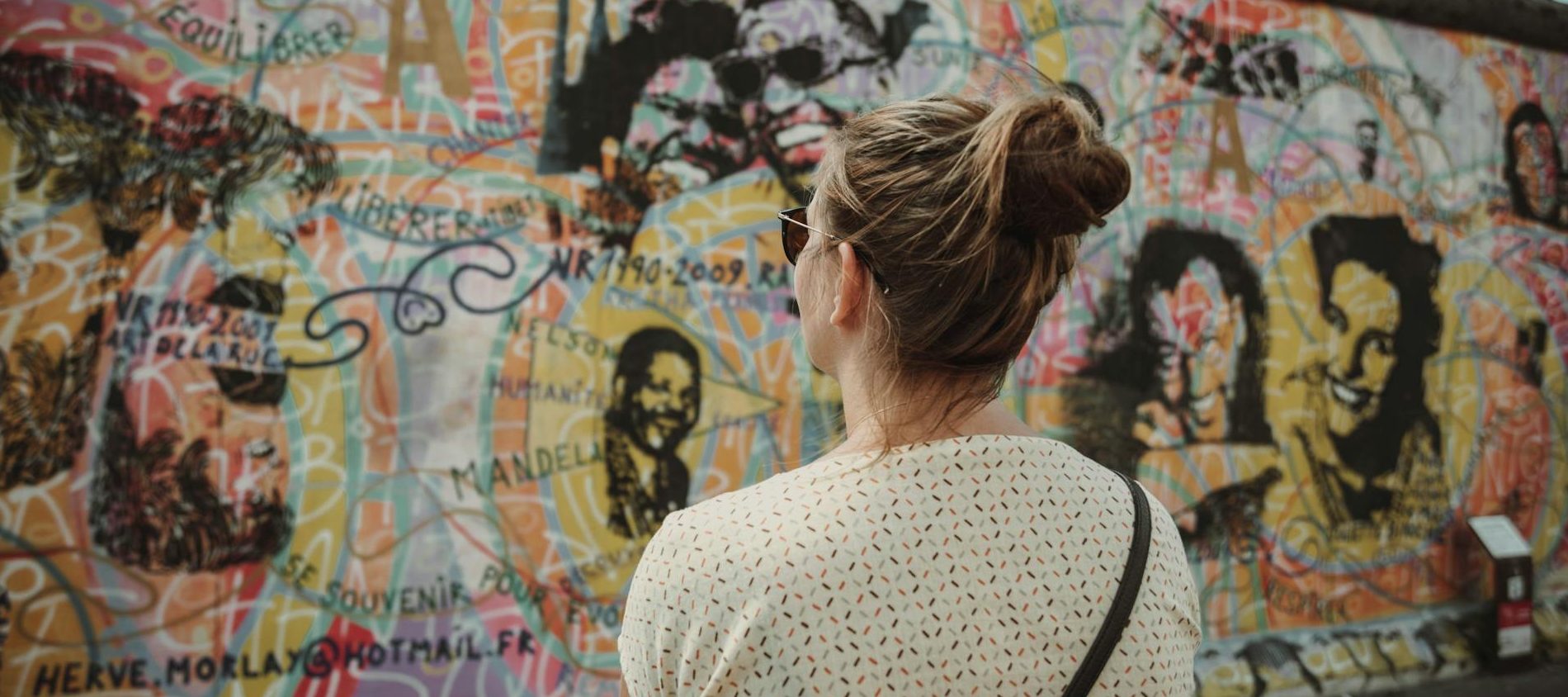 Berlin, BE, Germany A Woman Looking at the Berlin Wall - Move to Germany